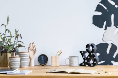Altın bir pot, ahşap el, saat ve yaprakları duvardaki bir bitki ile dağınık Danışma