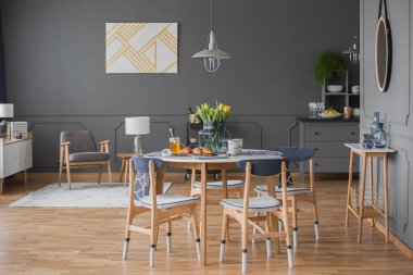 Geniş yemek odası iç gri duvar kalıp, Masa, sandalye, lale ve modern lamba