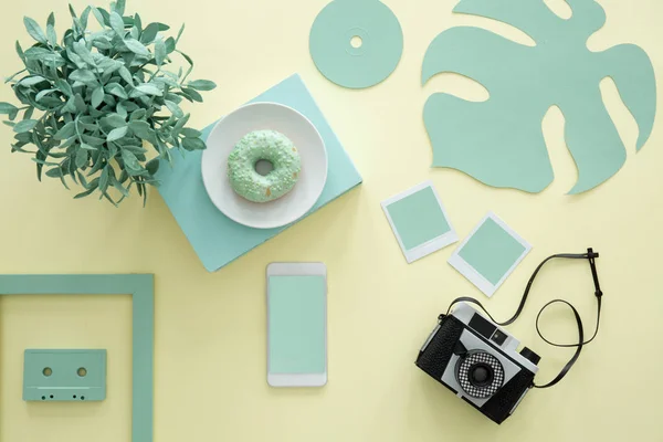 Top view of a creative blogger\'s table with camera, compact cassette and doughnut