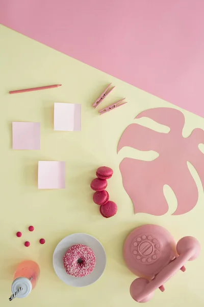 ピンクの電話と付箋 クリップ クッキーと黄色の背景の上にボトルのドーナツ — ストック写真
