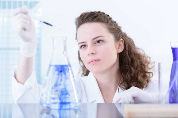 Химик Белом Халате Держит Пипетку Добавляет Голубое Вещество Лабораторную Фляжку — стоковое фото