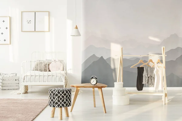 阳光照耀在一个时尚的小女孩的卧室的风景壁纸一个创意和功能的木衣架上的衣服 — 图库照片