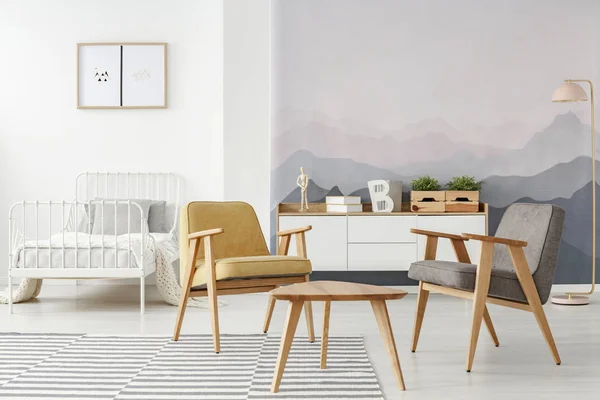黄色和灰色现代扶手椅和一张白色床在多功能房间内部与山壁纸和木家具 — 图库照片
