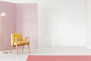 Yerde boş, parlak oda iç kopya alanı hardal koltuk, metal, pastel pembe lamba ve kırmızı halı ile fotoğraf yerleştirilir