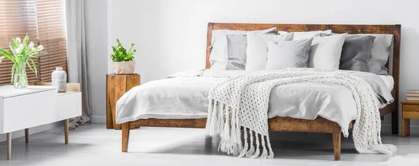 Wooden Frame Comfortable Bed Many Pillows Blanket Sheets Sideboard Flowers — стоковое фото