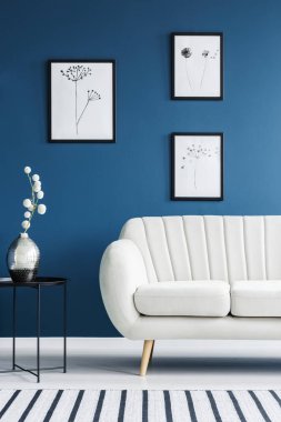 Çiçek poster, metal sehpa ve beyaz kanepe bir mavi salon iç ayarla
