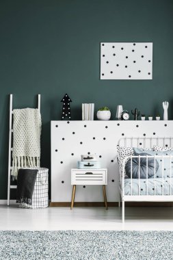 Beyaz yatak ve kabine çocuğun yatak odası iç yukarıda yeşil duvar üzerine desenli poster