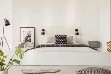 Bir yatak modern yatak odası iç bir platformda siyah beyaz çarşaf yastık ve gri battaniye ile gerçek fotoğraf