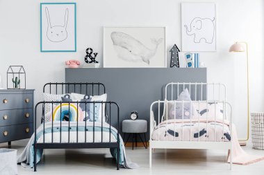 Gri çocuk yatak odası iç posterler ile siyah beyaz yataklar arasında dışkı. Gerçek fotoğraf