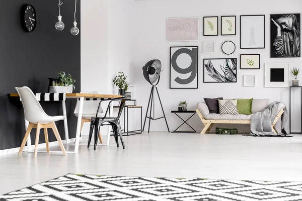黒と白の椅子ソファーの上のポスターと広々 としたアパート インテリアのダイニング テーブルに — ストック写真