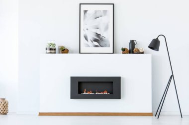 Şömine ve poster beyaz en az oturma odası iç yanındaki siyah lamba. Gerçek fotoğraf