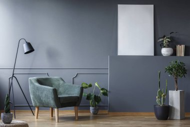 Yeşil koltukta oturma odası iç bitkiler ve poster mockup, yanındaki siyah lamba