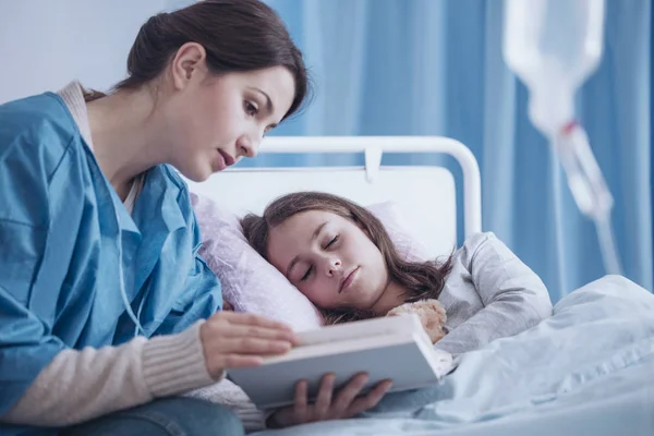 Mother Reading Book Her Sick Sleepy Daughter Clinic — Stock Photo, Image