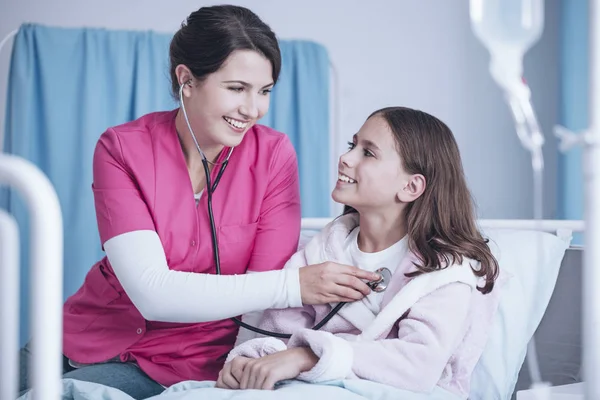 Hastanedeki Mutlu Kız Inceleyerek Stetoskop Ile Gülümseyen Hemşire — Stok fotoğraf