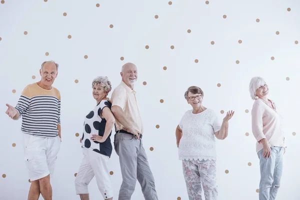 Äldre Människor Firar Nyårsafton Mot Vit Vägg Med Guld Prickar — Stockfoto