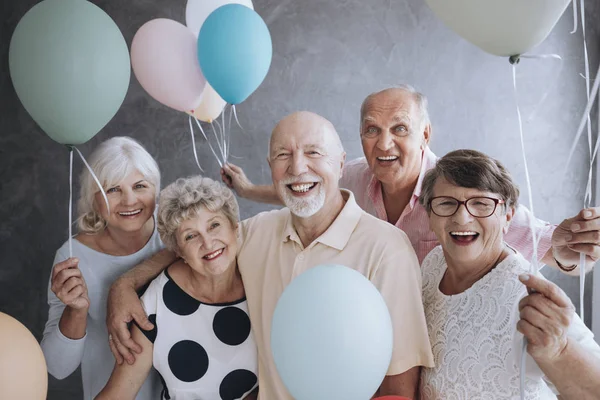 Ανώτερος Τους Φίλους Χαμογελώντας Πολύχρωμα Μπαλόνια Απολαμβάνοντας Συνάντηση — Φωτογραφία Αρχείου