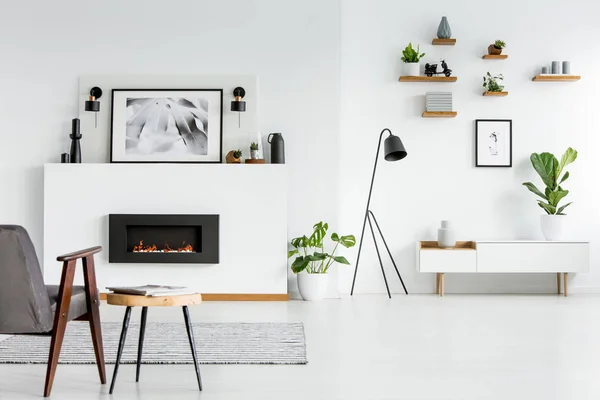 Grauer Sessel Neben Tisch Wohnzimmer Mit Schwarzem Kamin Und Poster — Stockfoto