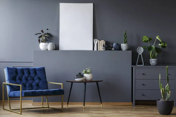灰色フラット インテリア ポスターや植物のモックアップでテーブルの横にあるネイビー ブルーの肘掛け椅子 — ストック写真