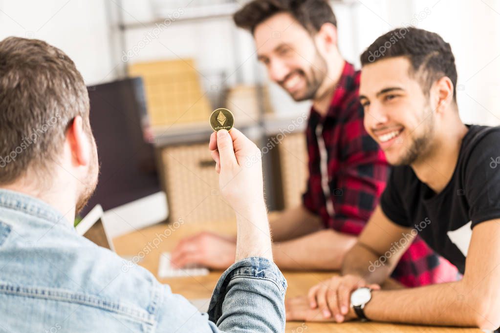 Happy financier with gold coin as a symbol of cryptocurrency. Making money on the Internet