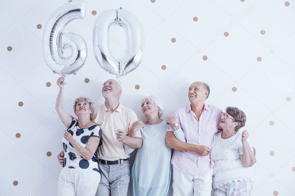 Grandmother and grandfather with silver balloons celebrating 60th birthday