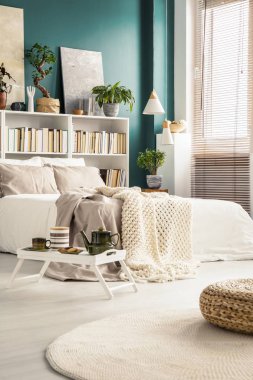 Pot ve modern yatak odası iç rahat bir yatakta önünde ayakta su bardağı beyaz tepsi