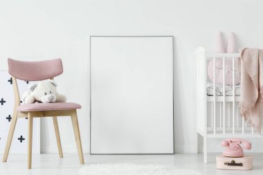 Peluş oyuncak bebek odası iç oda mockup poster yanındaki pembe sandalye üzerinde. Gerçek bir fotoğraf. Posterinizi buraya yapıştırın