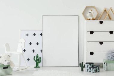 Yanındaki boş poster mockup çocuğun odası iç kaktüs motifi ile beyaz sallanan at. Gerçek bir fotoğraf. Posterinizi buraya yapıştırın