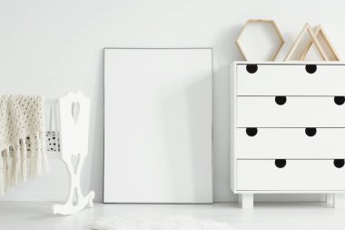 Mockup beyaz beşik ve basit çocuk odası iç dolapta arasında boş poster. Gerçek bir fotoğraf. Posterinizi buraya yapıştırın