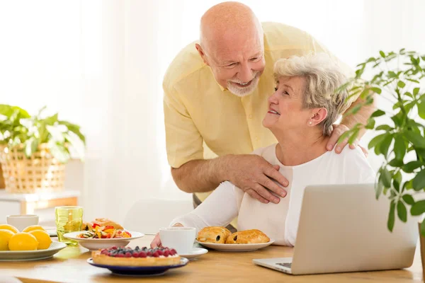 Lachende Grootvader Knuffelen Zijn Vrouw Die Het Internet Een Laptop — Stockfoto