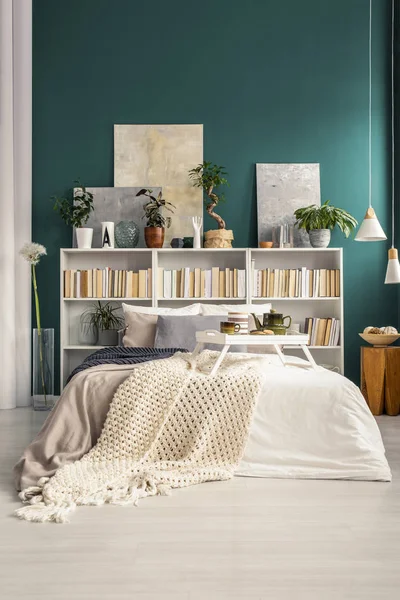 白色早餐托盘在舒适的床上与温暖的毯子在自然绿色公寓内部与家庭图书馆 — 图库照片