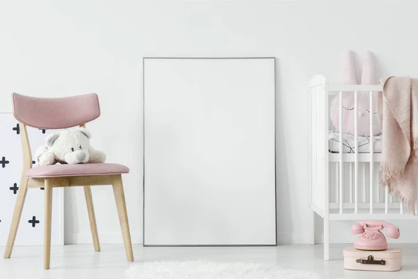毛绒玩具在粉红色的椅子旁边的海报与样机在婴儿的房间内与床 真正的照片 粘贴您的海报在这里 — 图库照片