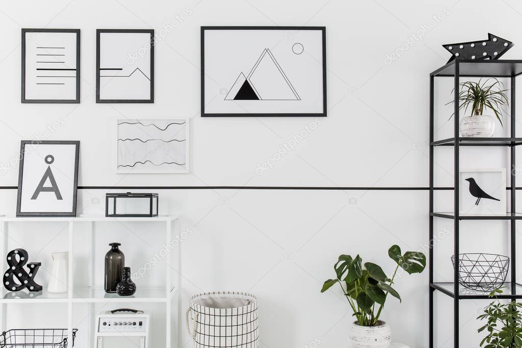 Simple black and white posters hanging on white wall in Nordic style living room interior
