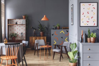Geniş gri daire masa ve koltukları yukarıda turuncu lambalı iç geometrik poster