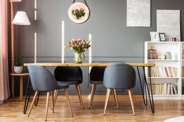 Ahşap yemek masası, gri sandalye, kitaplık ve yemek odası iç pembe laleler