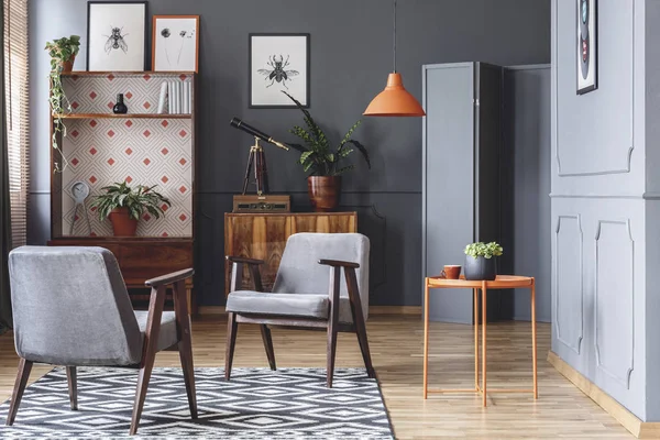 アームチェア オレンジ色のコーヒー テーブル 木製食器棚 リビング ルームのインテリアに灰色の壁 — ストック写真