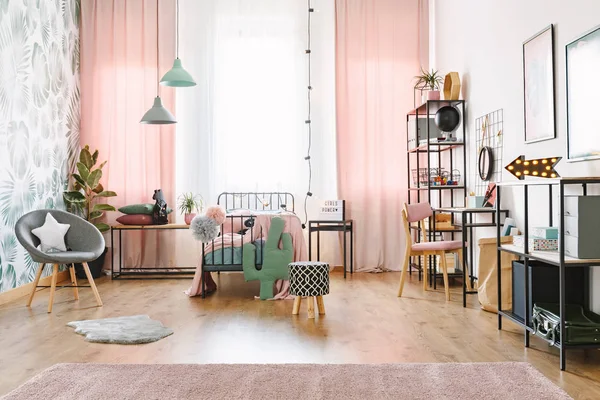 粉红色女孩房内设有单人床 灰色扶手椅和仙人掌形枕头 — 图库照片