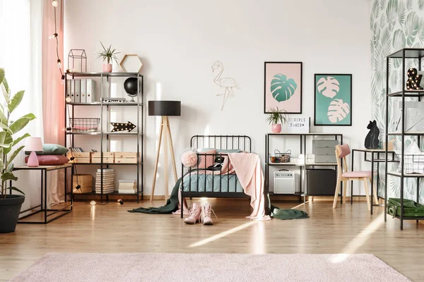 粉红色的椅子在书桌在柔和的卧室内部与绿色海报和鞋子在床附近 — 图库照片