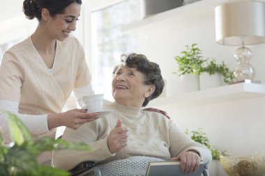 Dost gönüllü veren fincan çay bakım evinde mutlu kadın kıdemli için