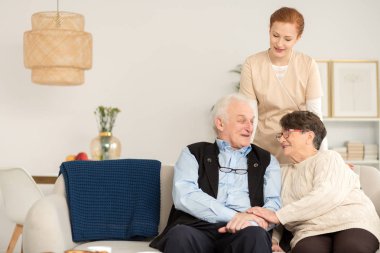 Bir kanepe ve onların hemşire evde oturan kıdemli mutlu çift 