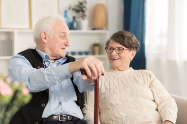 Pair of seniors talking about life in a luxury senior house clipart