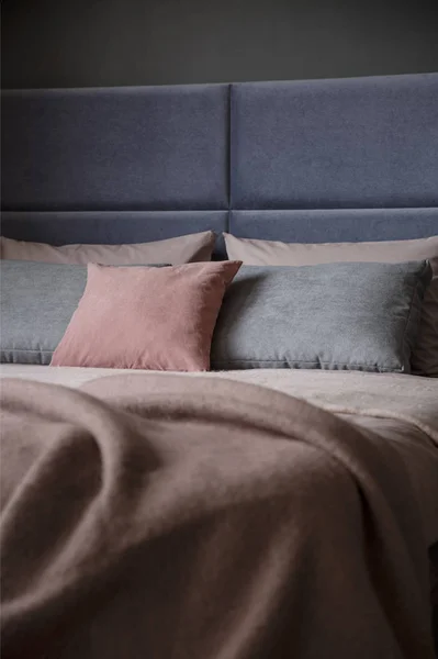 女性の寝室のインテリアのヘッドボードとベッドの上のグレーとピンクの枕 — ストック写真