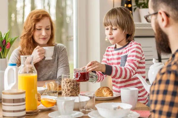 Kahvaltı hazırlarken, evde ailesi ile birlikte yemek yeme bir çocuk