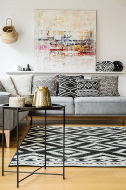 Desenli halı ve modern oturma odası iç boyama gri kanepe yastıkları. Gerçek fotoğraf