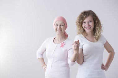 Hasta annesi pembe kanseri şerit ve mutlu kızı beyaz arka plan üzerinde izole elele