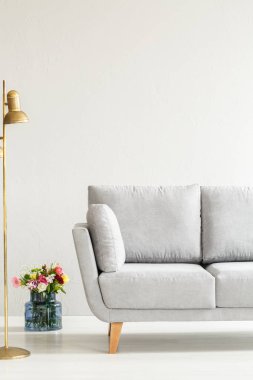 Gri kanepe ve altın lamba arkasında renkli çiçekli Beyaz zarif salon iç
