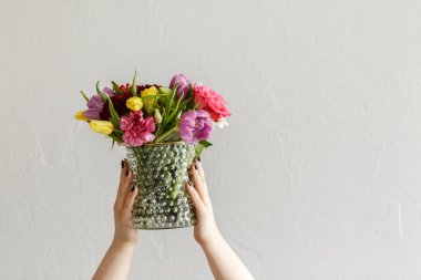 Kişi kopya alanı ile gri arka plan cam vazoda renkli çiçekli. Kadının gün kavramı