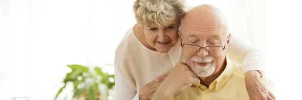 Een Oudere Man Glazen Naar Beneden Lezing Zijn Vrouw Achter — Stockfoto