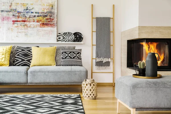 Yastıklar sıcak oturma odası iç resim ve şömine ile gri kanepe üzerinde. Gerçek fotoğraf