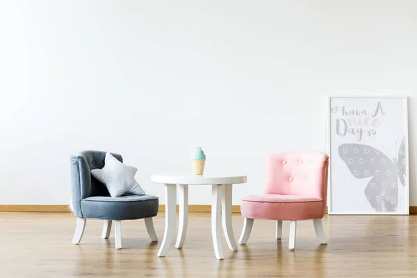 壁にポスターやコピー スペースと女の子の室内の白いテーブルでパステル カラーの椅子 実際の写真 — ストック写真