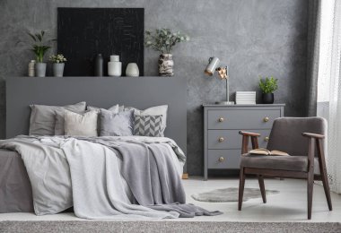 Gri tekli yatak yastık siyah posteri ile karanlık yatak odası iç ile yanındaki. Gerçek fotoğraf